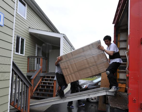two men moving a box off a truck